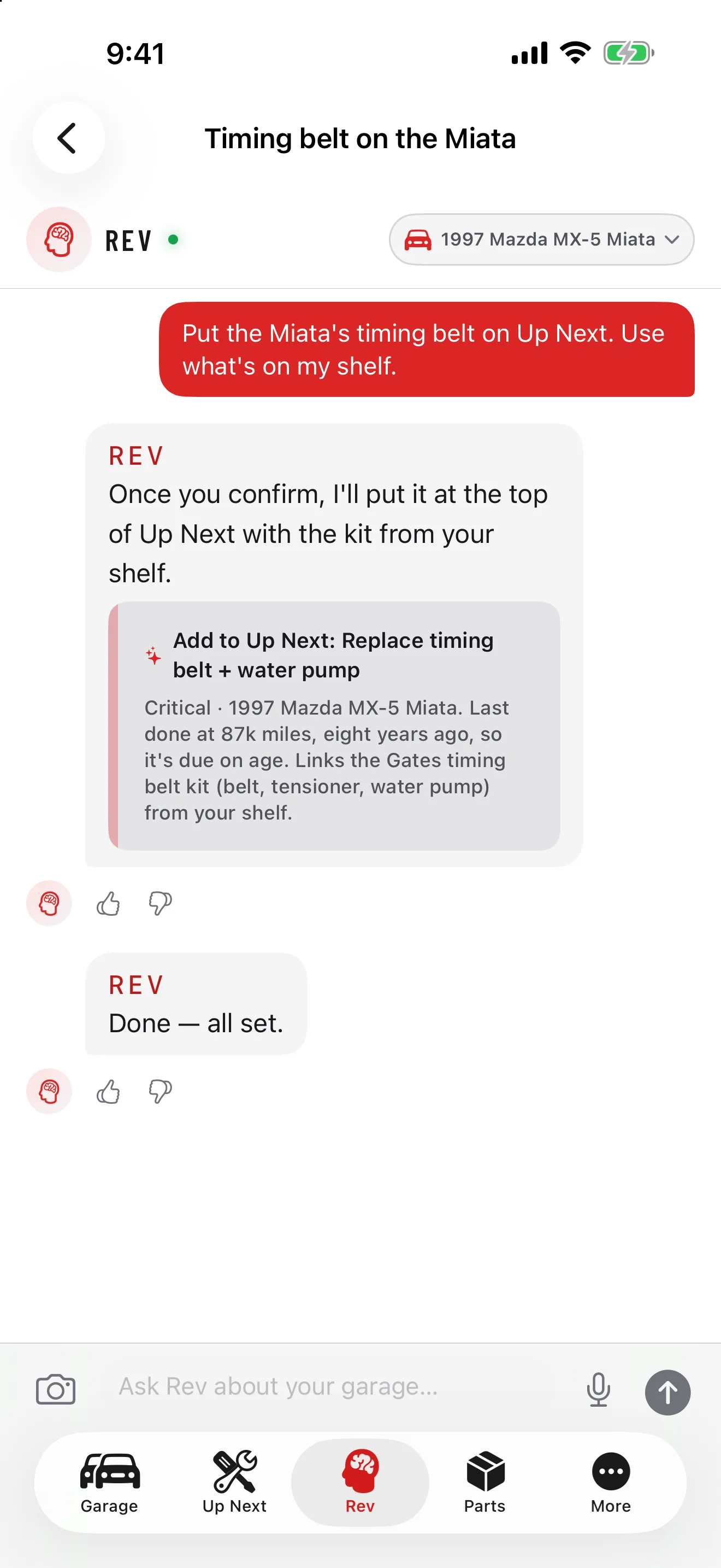 GarageHub no iPhone, chat do Rev para um Mazda MX-5 Miata 1997: solicitado a colocar a correia dentada em Próximo usando peças em estoque, o Rev exibe um cartão de confirmação para um serviço crítico de correia dentada e bomba d'água, realizado pela última vez a 140 mil km, há oito anos, com o kit Gates do estoque vinculado, então responde que está feito.